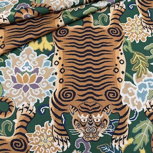 Könnte beinhalten: Detaillierter Stoff mit einem Tigerdesign mit braunen und schwarzen Streifen auf grünem Hintergrund. Der Stoff enthält auch Blumenmuster in Beige, Blau und Lila. Das Gesicht und der Körper des Tigers sind deutlich dargestellt.