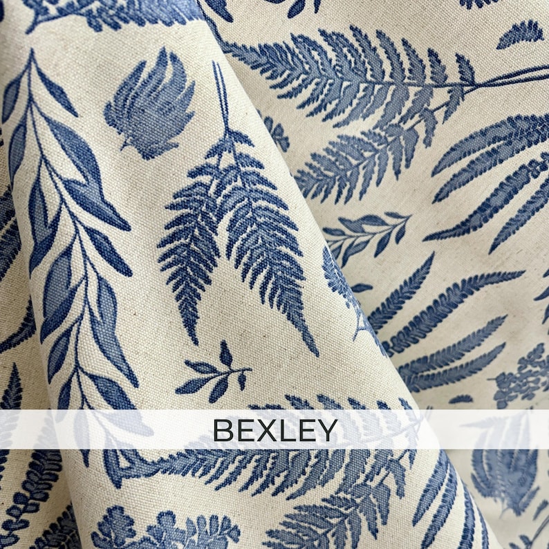 a close-up view of a fabric with a repeating pattern of blue fern leaves and other leaf-like designs. The fabric appears to be made of a light-colored material, possibly linen or a similar type of fabric. The text "BEXLEY" is visible in the image.