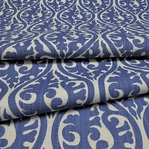 a close-up view of a fabric with a repeating pattern of blue and white swirls and curves. The pattern is intricate and detailed, creating a visually striking design.