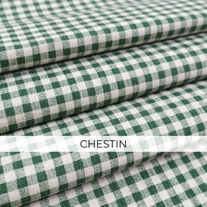 May include: A folded fabric featuring a classic green and white gingham check pattern. The textile displays a consistent woven texture throughout the layers. The word CHESTIN is printed in a clear, sans-serif font across the center of the image.