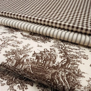 May include: Three stacked layers of fabric featuring a brown and white gingham check pattern, a brown and white ticking stripe pattern, and a cream-colored textile with a brown toile de jouy print depicting pastoral scenes with figures and trees.