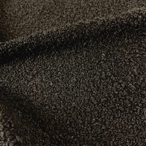 May include: A dark brown fabric with a dense, curly, and textured surface. The material features a looped pile construction that creates a thick, uneven, and tactile appearance across the entire visible area of the textile.