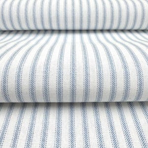 Peut inclure: Un tissu textile pr&eacute;sentant un motif r&eacute;p&eacute;titif de rayures verticales bleues sur un fond blanc. Le mat&eacute;riau poss&egrave;de une texture tiss&eacute;e visible avec une densit&eacute; de tissage constante, montrant plusieurs plis du tissu superpos&eacute;s horizontalement.
