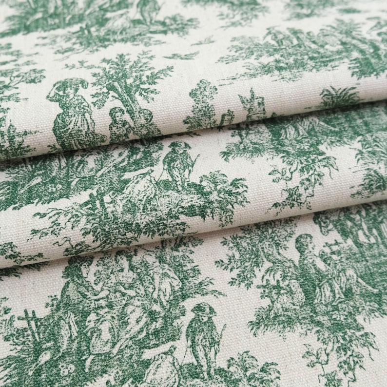 May include: A cream-colored fabric featuring a repeating dark green toile print. The pattern depicts detailed pastoral scenes with figures, trees, and foliage arranged in a classic narrative style across the textured woven textile surface.