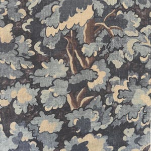 May include: A close-up of a fabric with a floral pattern. The design features stylized blue and beige flowers and leaves against a dark background. Brown tree trunks and branches are also visible, creating a natural, botanical theme.