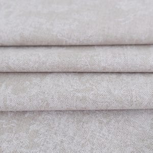 May include: A folded piece of light beige fabric with a subtle, mottled texture. The material features a woven appearance with a soft, neutral color palette and visible horizontal folds that create depth across the surface of the textile.
