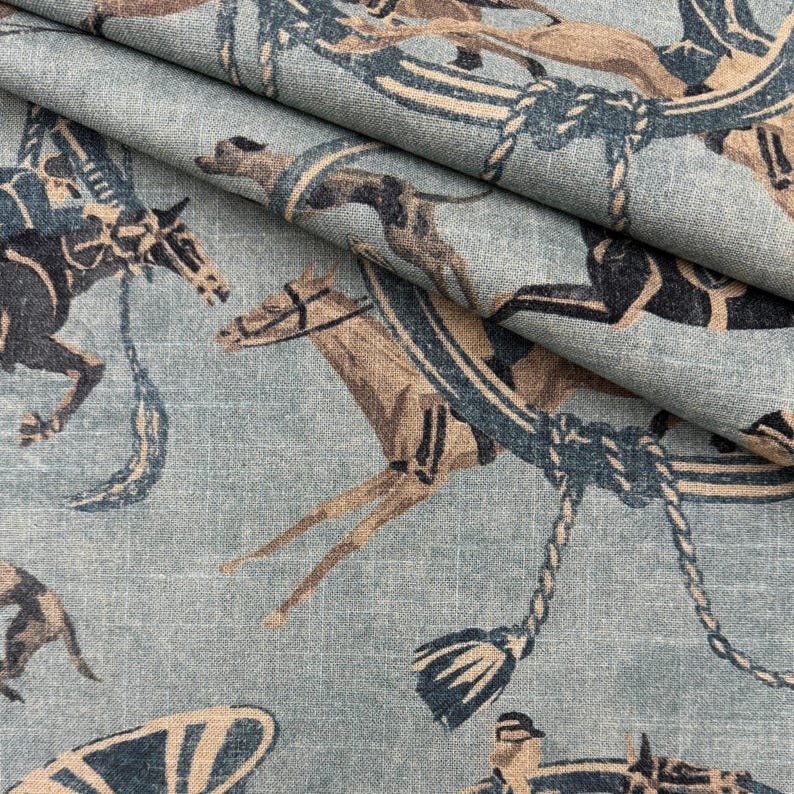 Puede incluir: Primer plano de una tela azul claro con un patr&oacute;n repetido de caballos y elementos ecuestres. Los caballos est&aacute;n representados en tonos marrones y negros, con detalles azules. La tela tiene un aspecto texturizado.