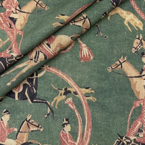 May include: Green fabric with a repeating pattern of equestrian figures, horses, and hounds in shades of tan, black, and red. The design features riders on horseback, hunting dogs, and decorative horn shapes, creating a vintage aesthetic.