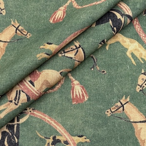 May include: Green fabric with a repeating pattern of horses, dogs, and equestrian equipment in tan, black, and red. The fabric has a textured appearance, with the design elements arranged in a scattered layout. The horses are depicted in various poses.