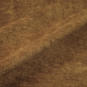 May include: A solid brown fabric with a soft, textured surface and a subtle, mottled appearance. The material features a dense, short-pile finish that creates gentle shadows and highlights across the folds of the draped textile material.
