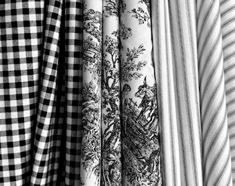 May include: A collection of folded fabric bolts featuring three distinct patterns: a black and white gingham check, a white fabric with a detailed black toile de jouy pastoral scene, and a white fabric with thin black vertical pinstripes.