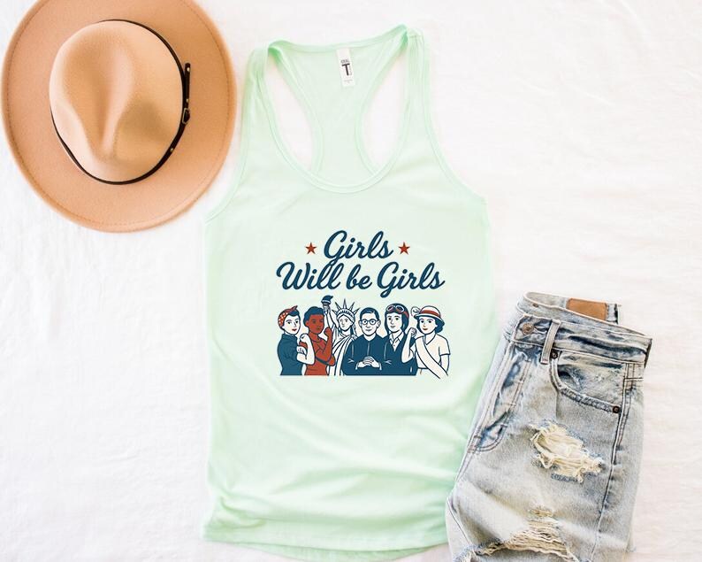 Pode incluir: Uma regata verde claro com o texto "Girls Will be Girls" e um gr&aacute;fico de seis mulheres. A regata &eacute; combinada com shorts jeans e um chap&eacute;u bege.