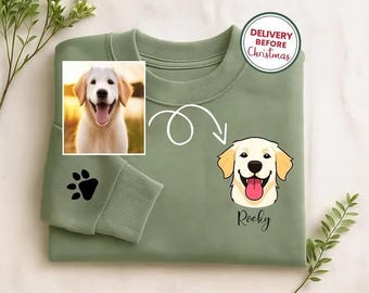 May include: Sage green sweatshirt featuring a smiling golden retriever illustration with the name "Rocky" below. A paw print is on the sleeve. The sweatshirt has a photo of a golden retriever and a "Delivery Before Christmas" sticker.