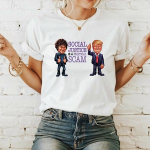 May include: White t-shirt featuring a cartoon image of two men. The text on the shirt reads "Social Justice is a Political Scam".