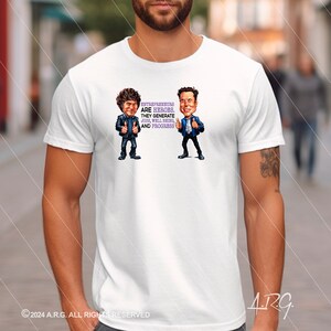 May include: White t-shirt featuring a cartoon illustration of two men with the text "Entrepreneurs are heroes. They generate jobs, well being, and progress".