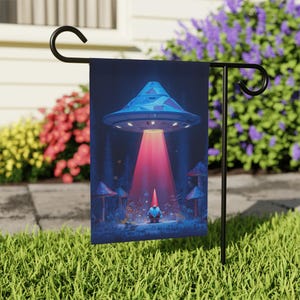 May include: A garden flag depicting a whimsical scene of a UFO beaming a gnome. The UFO is blue with a geometric pattern, and the gnome is wearing a red hat. The background includes mushrooms and trees, with a dark blue sky.