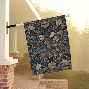 Puede incluir: Una bandera rectangular para exteriores con un fondo azul marino oscuro y un detallado diseño floral en tonos marrón, beige y azul. La bandera cuelga de un poste blanco, añadiendo un toque de elegancia a cualquier espacio exterior. El patrón floral es intrincado.