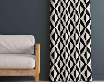 May include: A floor-length curtain featuring a repeating geometric pattern of black and white interlocking diamond and oval shapes. The fabric hangs in vertical folds, displaying a high-contrast graphic design that covers the entire surface area.