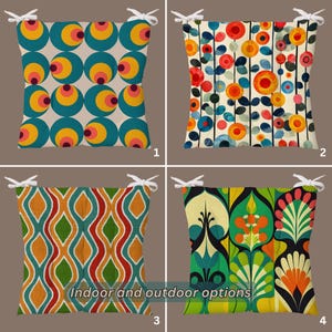 Puede incluir: Cuatro cojines de asiento cuadrados con lazos blancos en las esquinas. El cojín 1 tiene círculos en color verde azulado, amarillo y rosa. El cojín 2 presenta motivos florales rojos y naranjas sobre líneas verticales. El cojín 3 muestra líneas onduladas naranjas, verdes y rojas. El cojín 4 exhibe motivos botánicos verdes, naranjas y negros.