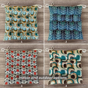 Puede incluir: Cuatro cojines cuadrados para asiento con lazos, cada uno con un patrón distinto: círculos azules y naranjas, contornos de hojas azules, formas florales rojas y negras, y formas redondeadas abstractas en color verde azulado y melocotón.