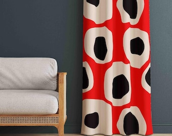 May include: A floor-length curtain featuring a bold graphic pattern of large, irregular off-white circular shapes with solid black centres, all set against a vibrant, solid red background. The fabric hangs in vertical folds, displaying the repeating design.