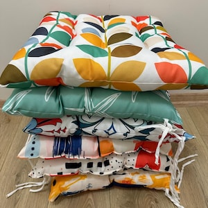 a pile of pillows sitting on top of a wooden floor