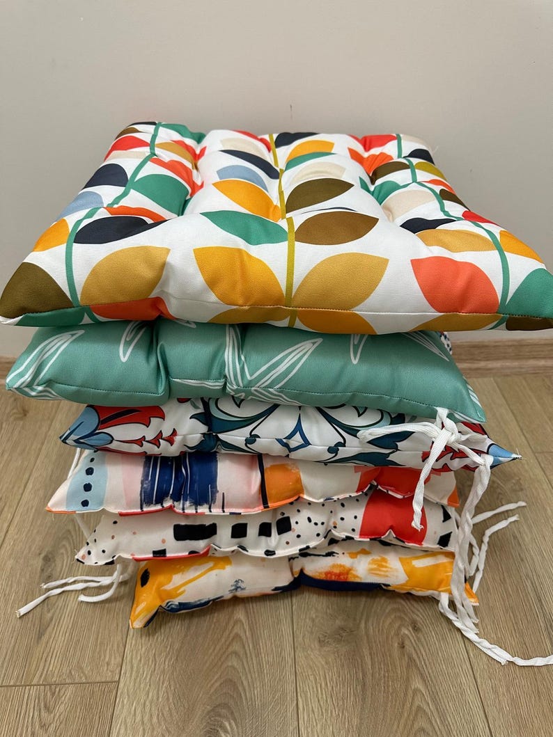 a pile of pillows sitting on top of a wooden floor