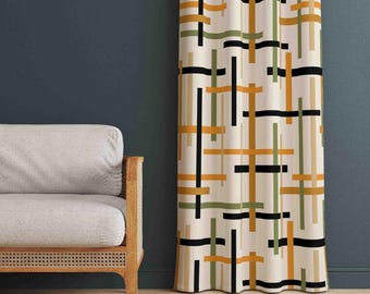 Pode incluir: Uma cortina de comprimento total com fundo branco e um padrão de grade de linhas verticais e horizontais que se cruzam em tons de amarelo mostarda, verde oliva e preto. O tecido cai em dobras verticais suaves ao lado de um sofá cinza claro.