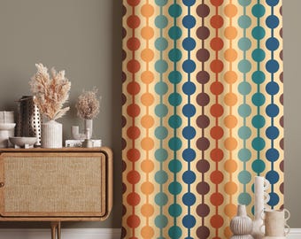 May include: A curtain featuring a repeating vertical pattern of solid circles in shades of dark blue, teal, orange, and brown against a light cream background. The fabric hangs in soft, vertical folds, displaying a consistent geometric design.