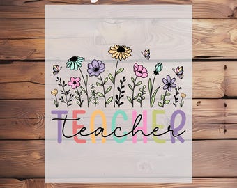 May include: A DTF transfer with a floral design and the word "Teacher" in colorful letters. The design features various flowers, butterflies, and the text "Ready To Press".