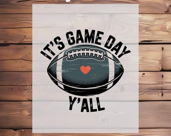 May include: A DTF transfer design featuring a football with the text "IT'S GAME DAY Y'ALL". The football is dark gray with a red heart and white stitching. The words "Ready To Press" and "DTF Transfer" are also included.