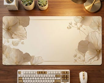 Può includere: Tappetino da scrivania color crema con un motivo floreale dorato. Una tastiera e un mouse bianchi e dorati sono posizionati sotto. L'allestimento della scrivania comprende un portapenne in marmo, piante grasse e una lampada da scrivania dorata.