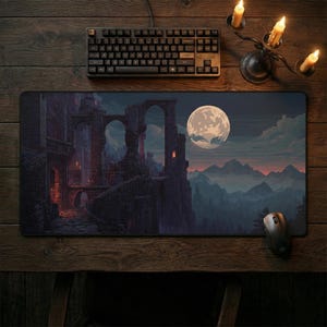 Peut inclure: Tapis de souris rectangulaire avec un paysage fantastique pixélisé, une pleine lune, des ruines de château et des montagnes. Un clavier noir et une souris sont sur une surface en bois, avec un bougeoir.