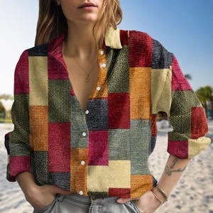 Op de afbeelding: Een button-down shirt met lange mouwen en een patchwork-ontwerp in rood, oranje, geel, groen en grijs. Het shirt met kraag is gemaakt van een textuurstof. De bovenste knoop van het shirt is los.