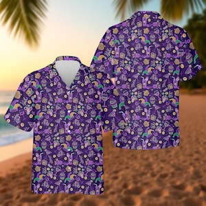 May include: Two short-sleeved button-down shirts with a purple background and a repeating pattern of Mardi Gras-themed icons. The pattern includes cupcakes, cocktails, and jester hats in green, yellow, and purple.