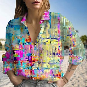 May include: A button-down shirt with a vibrant, abstract design in shades of blue, pink, yellow, and green. The long-sleeved shirt has a collared neckline and a relaxed fit, perfect for casual wear. The colorful pattern gives the shirt a unique, artistic look.