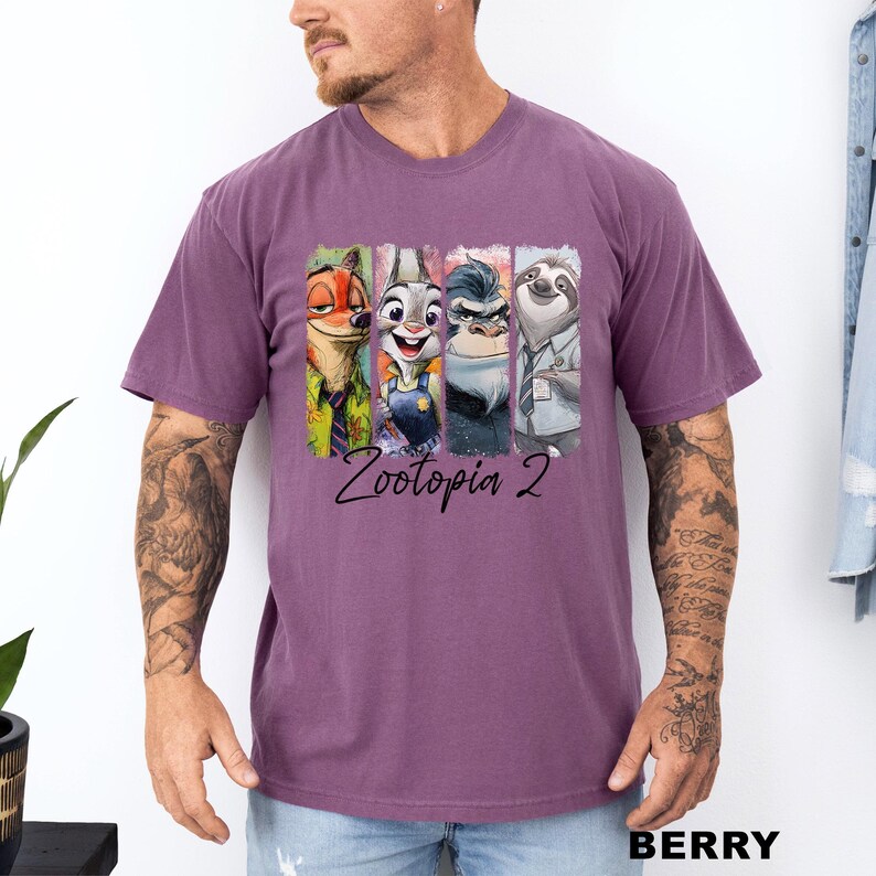 Puede incluir: Camiseta de color bayas con un gr&aacute;fico de personajes de Zootopia 2. El dise&ntilde;o incluye a Nick Wilde, Judy Hopps, el jefe Bogo y Flash. El texto "Zootopia 2" est&aacute; impreso debajo de los personajes.