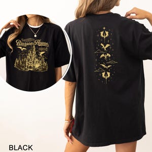 May include: Black t-shirt with a gold graphic of a castle and the text "Riorson House" on the front. The back of the shirt features a vertical design of gold dragons and clouds. The word "BLACK" is at the bottom of the image.