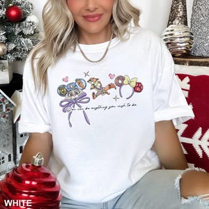 Puede incluir: Camiseta blanca con un gr&aacute;fico de dibujos animados de personajes y accesorios. El dise&ntilde;o incluye un rat&oacute;n con uniforme de polic&iacute;a, un zorro y diademas tem&aacute;ticas. Tambi&eacute;n se incluye el texto "You can be anything you wish to be".