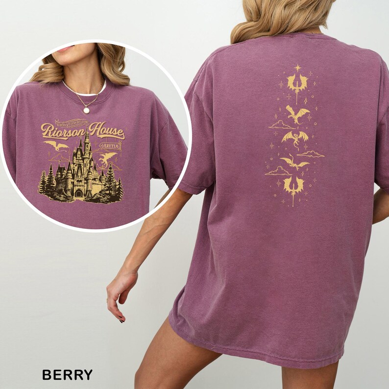 May include: Berry-colored t-shirt with a graphic of a castle and the text "Riorson House" on the front. The back features a gold design of dragons and clouds. The shirt is a relaxed fit.