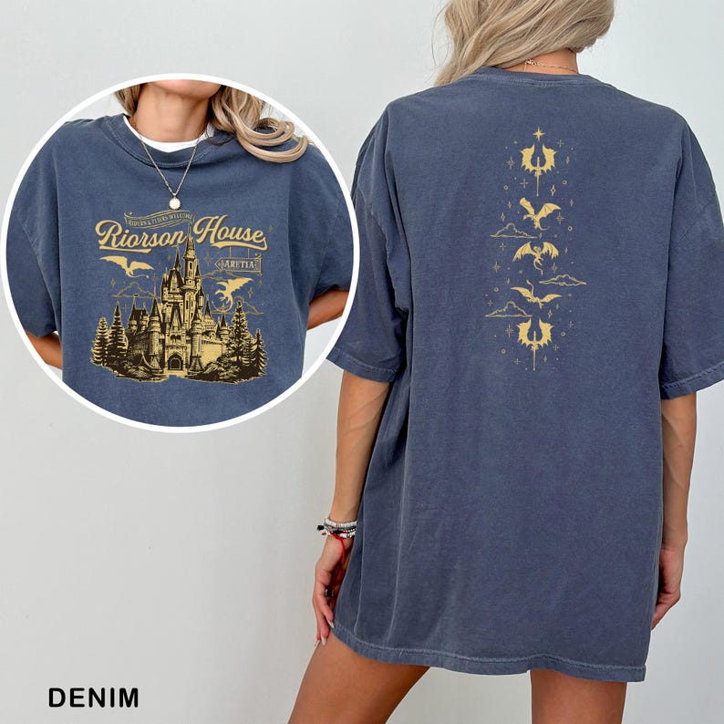 May include: Denim blue t-shirt with a gold graphic of a castle and the text "Riorson House" on the front. The back features a vertical gold design of dragons and clouds. The shirt is a relaxed fit.