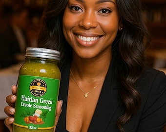 May include: A clear glass jar filled with Haitian Green Creole Seasoning, featuring a green label with the text Haitian Green Creole Seasoning and 32 oz. The jar has a silver metal lid and contains a thick, textured green herb-based sauce.