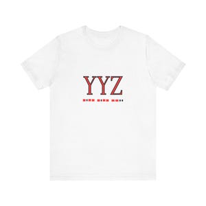 Könnte beinhalten: Weißes T-Shirt mit einer roten und schwarzen Grafik, auf der "YYZ" steht, und darunter eine Reihe kleiner roter und schwarzer Quadrate.