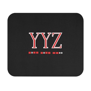 Peut inclure: Un tapis de souris noir avec les lettres "YYZ" en rouge avec un contour blanc. Sous les lettres se trouve une rangée de points rouges et blancs.
