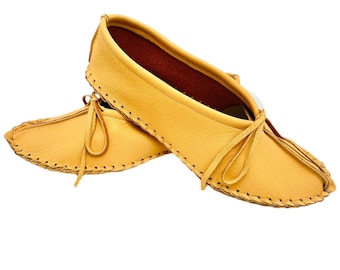 May include: A pair of yellow leather moccasins featuring a soft, flexible construction with visible whipstitch detailing along the edges and a thin leather lace tied in a bow at the top of the vamp for a secure fit.