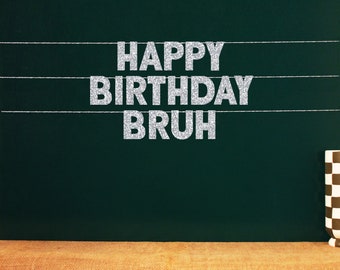 May include: A green chalkboard with the words "Happy Birthday,  Bruh" written in silver glitter letters.