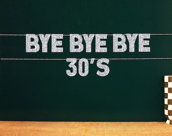 May include: Silver glitter letters spelling "Bye Bye Bye 30's" on a dark green chalkboard background.