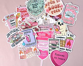 Puede incluir: Una colección de pegatinas coloridas con diseños temáticos de libros. Las pegatinas presentan frases como "Pretty Girls Read", "Open to Book Recs" y "Enemies to Lovers". Otros diseños incluyen libros, velas y un fantasma leyendo.