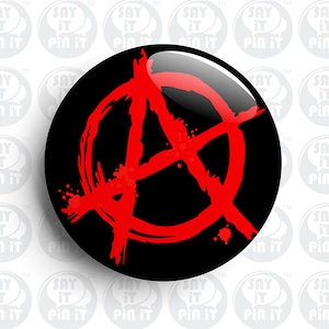 May include: A black and red anarchy symbol button. The symbol is a stylized letter A with a circle around it and a diagonal line through it. The symbol is red and the background is black.