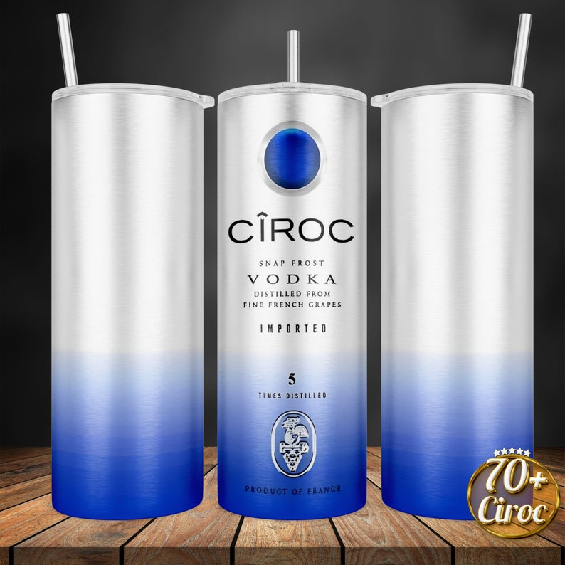 May include: A stainless steel tumbler with a blue to silver gradient design. The tumbler features the C&Icirc;ROC vodka logo and text, including "Snap Frost Vodka", "Distilled from Fine French Grapes", "Imported", "5 Times Distilled", and "Product of France".